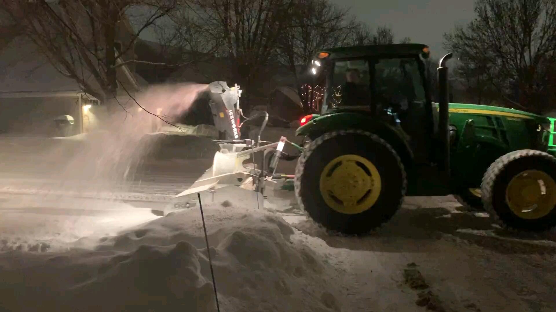 Iceworks tractor clearing the city plow ridge at the end of a residential driveway in Blaine, MN