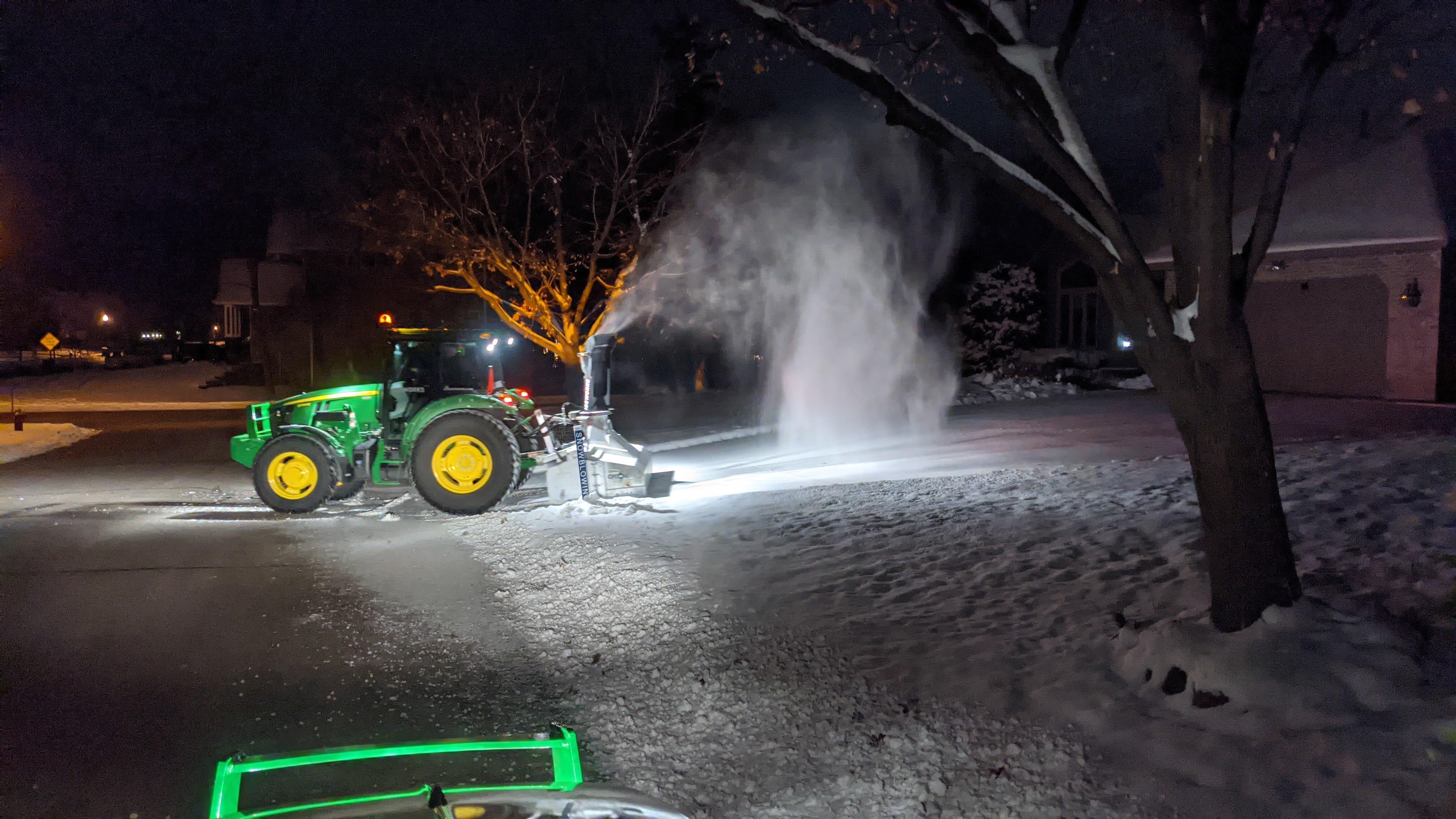 Iceworks tractor with inverted snowblower clearing a residential driveway in Blaine, MN