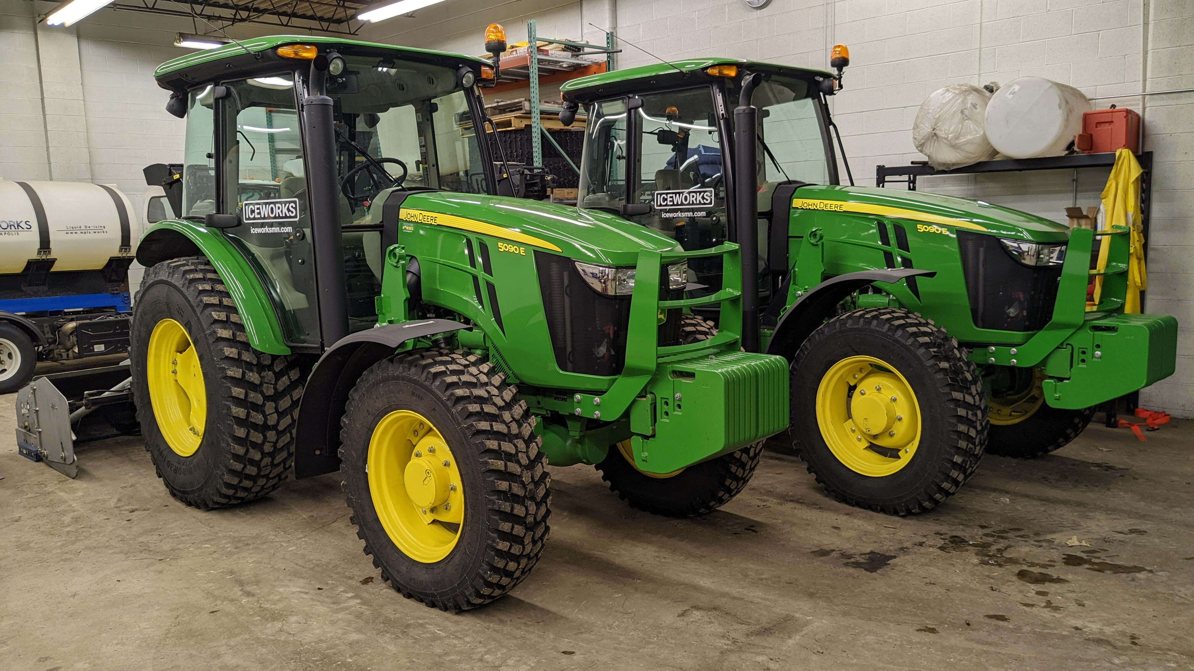 Iceworks John Deere tractors with inverted snowblowers lined up ready for residential snow removal in Blaine, MN